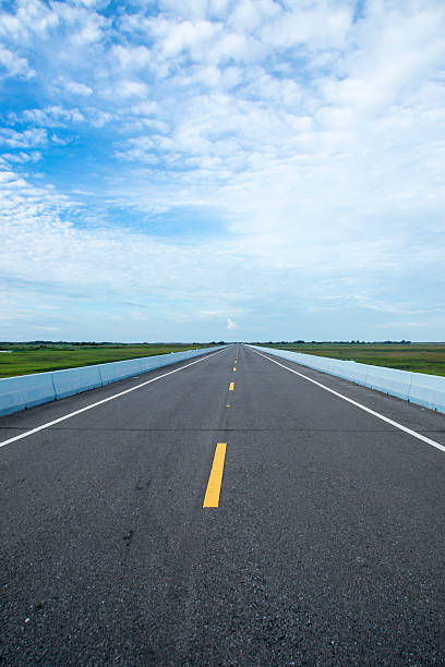 istock Empty road and the yellow traffic lines with clouds. 473070454