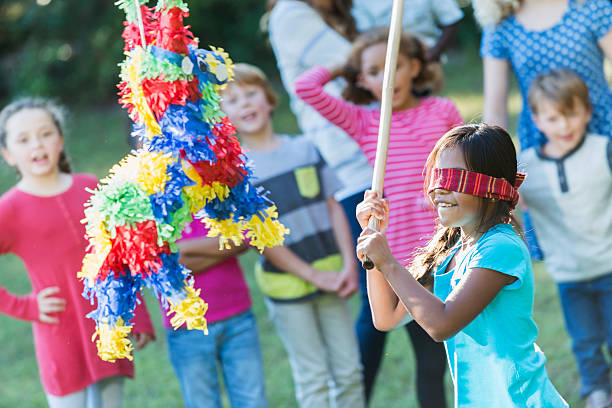istock Little girl wearing blindfold hitting a pinata 473071408