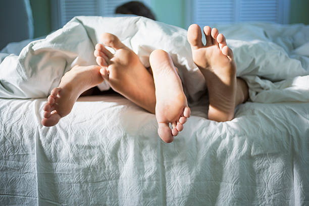 giovani amanti sotto le coperte al mattino - sesso e riproduzione sessuale foto e immagini stock