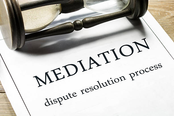 Mediation guideline papers with a sand clock placed sideways Mediation - dispute resolution process. mediation photos stock pictures, royalty-free photos & images