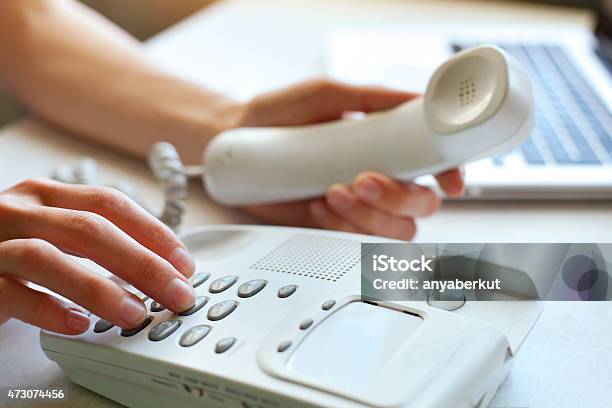 A Woman Using A Landline Phone Stock Photo - Download Image Now - Telephone, Using Phone, Stationary