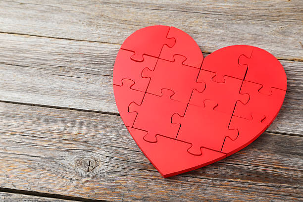 istock Red puzzle heart on grey wooden background 473078148