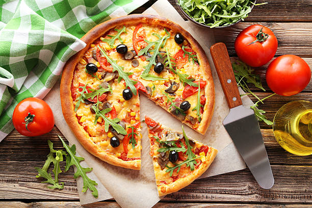 istock Fresh tasty pizza on brown wooden background 473078290