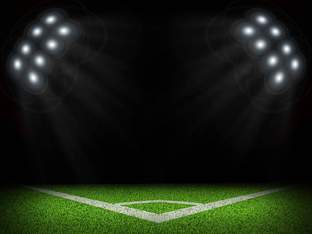 istock Corner of empty green field with bright spotlights 473078458