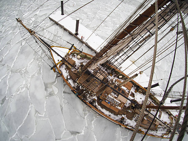Vintage photo of old wooden tallship or sailboat frozen in ice, looking down from aloft