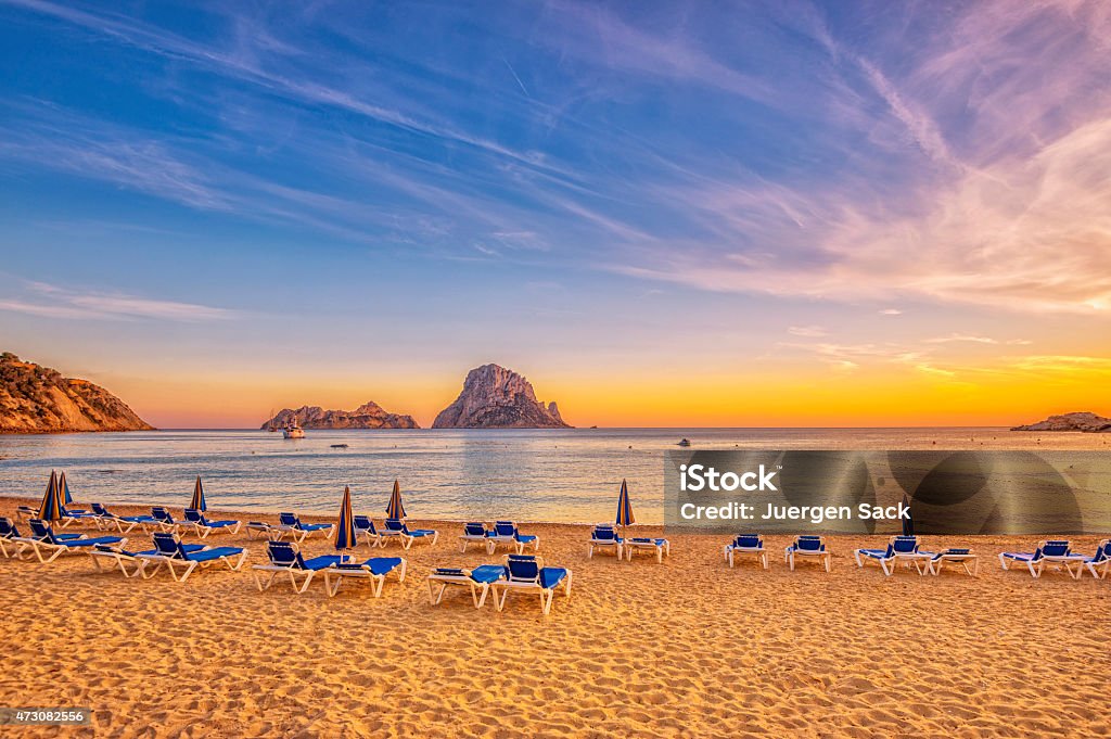 Beautiful sunset beach at Cala d´Hort on Ibiza Beautiful beach, boats and Es Vedrà - a small, uninhabited rock island - in the bay of Cala D'hort, Ibiza (Spain) at sunset.  Beach Stock Photo