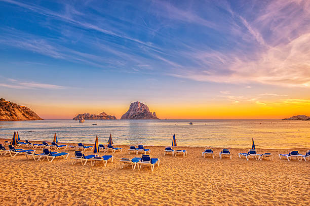 Beautiful sunset beach at Cala d´Hort on Ibiza Beautiful beach, boats and Es Vedrà - a small, uninhabited rock island - in the bay of Cala D'hort, Ibiza (Spain) at sunset.  balearic islands stock pictures, royalty-free photos & images