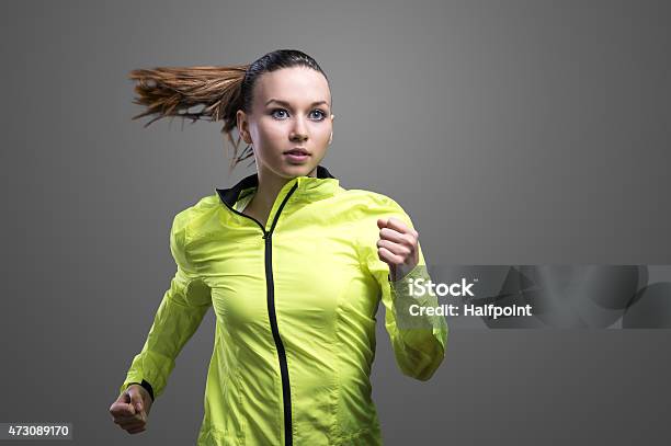 Beautiful Woman Runner In Green Jacket Stock Photo - Download Image Now - Jacket, Gray Color, Running