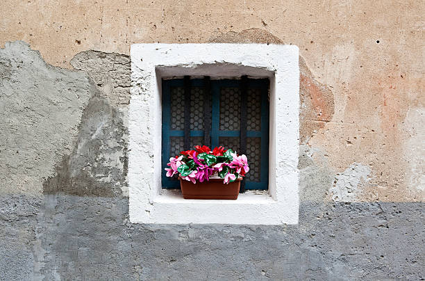 istock Flowers in Old window in Italian town 473089972