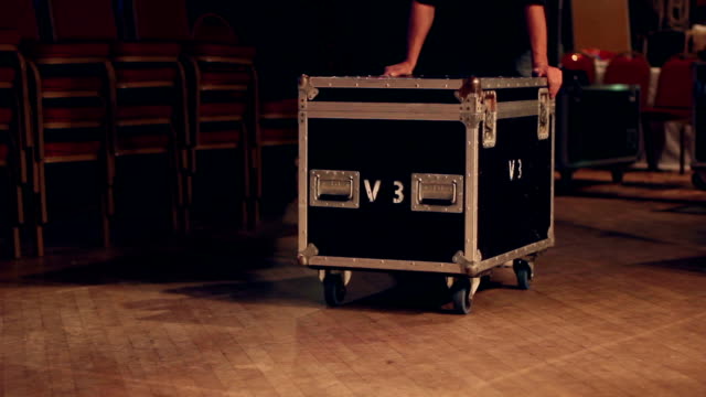 Technician / Roadie pushes a flightcase on stage