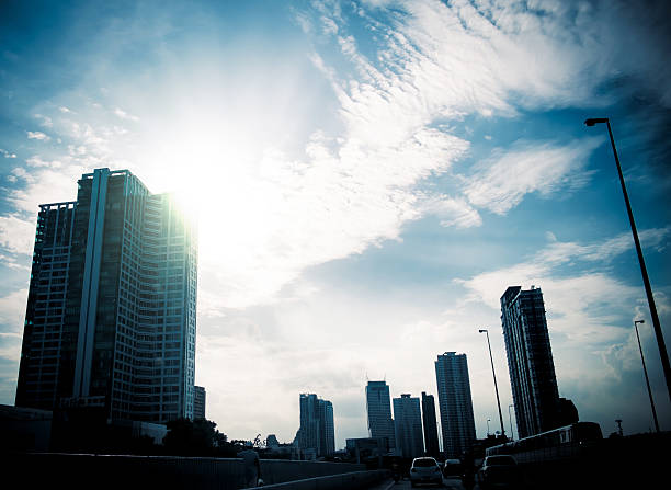 silhouettes city building with sun burst and blue sky,city skyscraper.