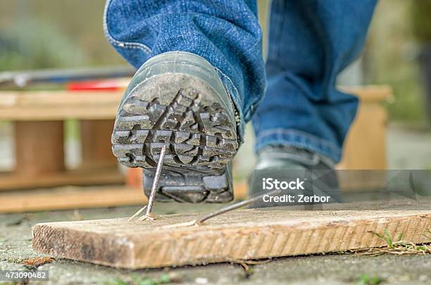 Worker In Safety Boots About To Step On A Nail Stock Photo - Download Image Now - Construction Site, Danger, Misfortune