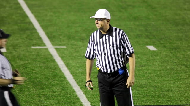 Three refs discuss a foul on the field