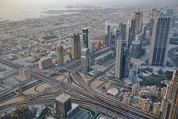 High-angle view of a busy urban highway surrounded by modern skyscrapers and residential buildings, capturing the dynamic city life and infrastructure.