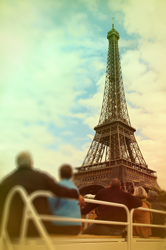 Abstract background .Tourists looking at the Eiffel Tower from the excursion boat. Blur effect defocusing filter applied, with vintage instagram look.