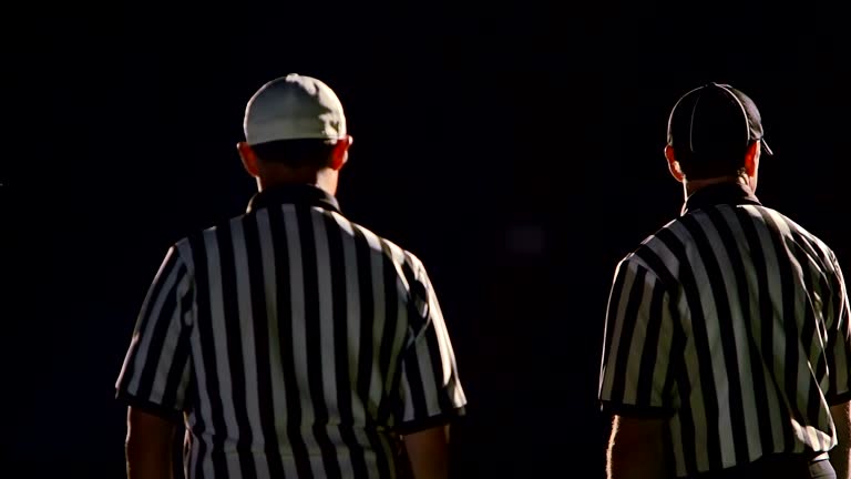 Three refs stand on the field talking