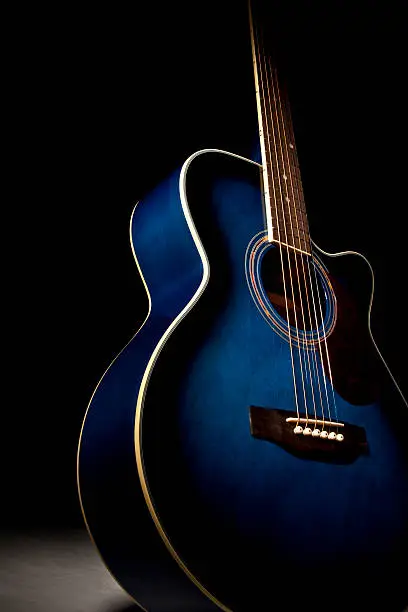 Photo of Blue guitar with dramatic lighting