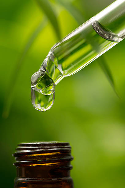 istock Herbal essence dropper dripping fluids into a bottle 473112772