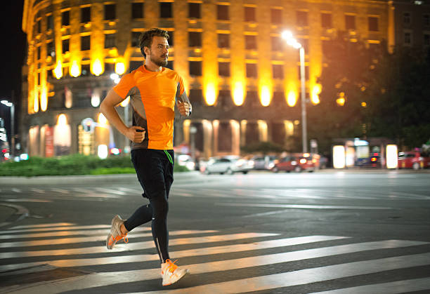 istock Young man jogging through the city at night. 473118190