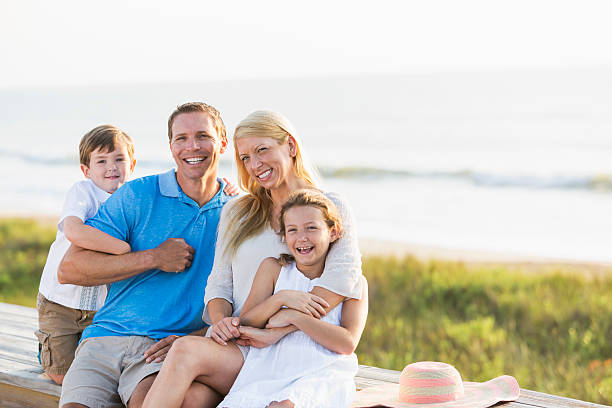 istock Family of four on beach boardwalk 473121304