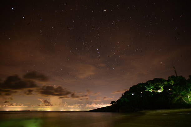 Wide angle image using a long exposure and high ISO of the tropical islands at night off Thailand mainland 34 miles away which light pollution can be seen in the distance.