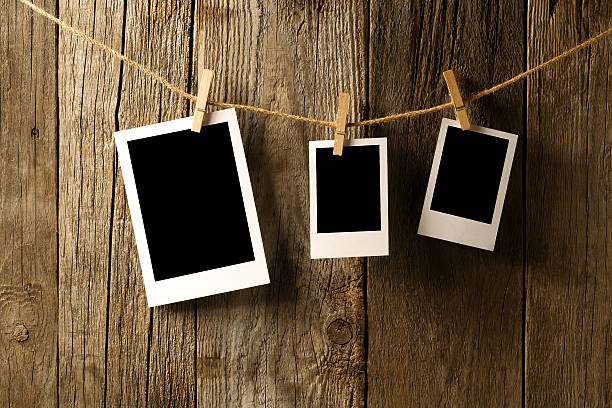 istock Blank photographs hanging on old wooden wall 473127256