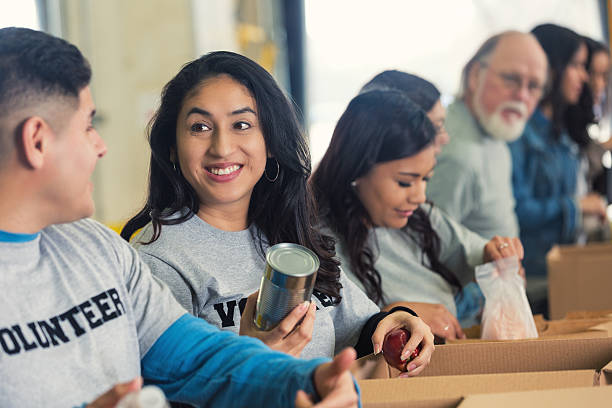istock Diverse volunteers sorting food into cardboard boxes for charity 473129912