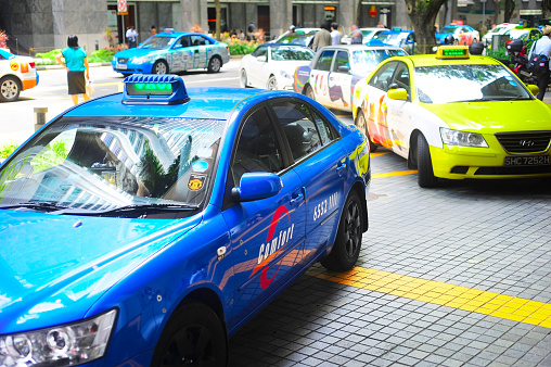 Singapore, Republic of Singapore -  March 06, 2013 : Taxi cabs on the road in Singapore. The government will spend SGP$14 billion to improve Singapore's road infrastructure