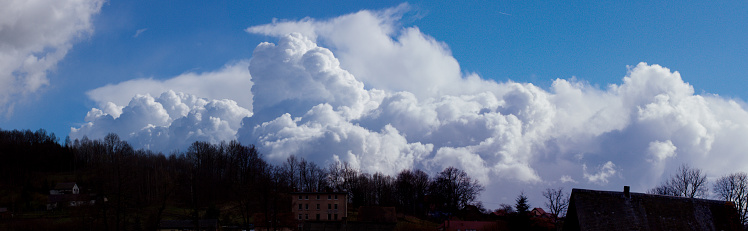 Panarama of a horizontal white cloud running over the blue sky