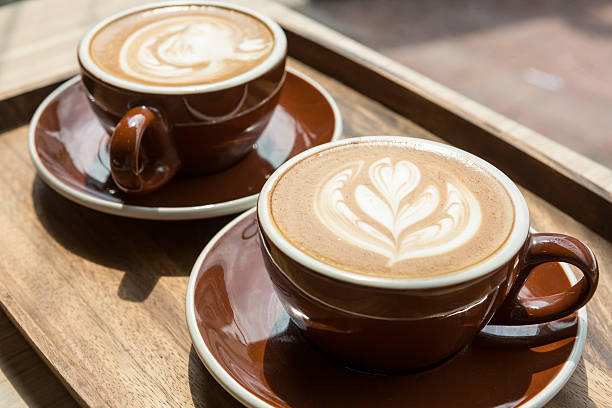 2 つのホットラテ - latté coffee tray froth ストックフォトと画像