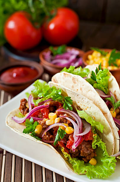 istock Mexican tacos with meat, vegetables and red onion 473146468