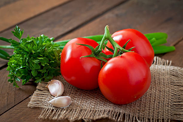 istock Branch of fresh tomato on wooden background 473147050