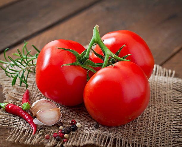 istock Branch of fresh tomato on wooden background 473147064