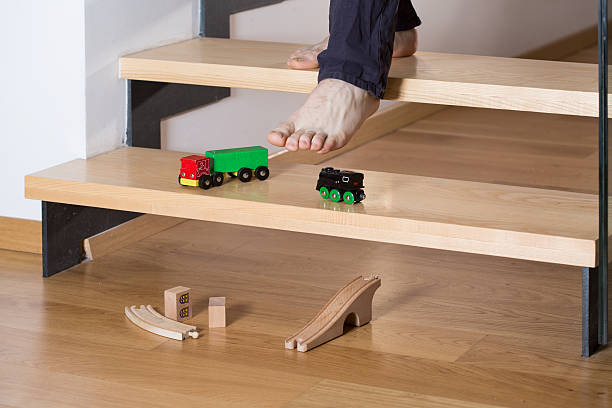 Close-up of toys on stairs Close-up of man's foot stepping on toys on stairs kid tripped stock pictures, royalty-free photos & images