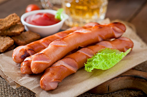 istock Grilled sausages, crackers and beer on a wooden background 473148312