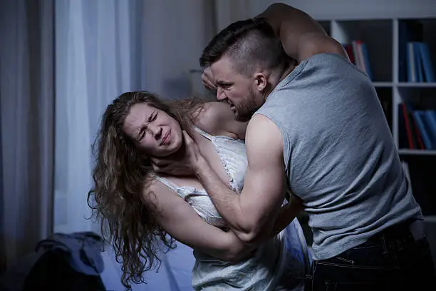 Threatening man strangling his terrified defenseless wife