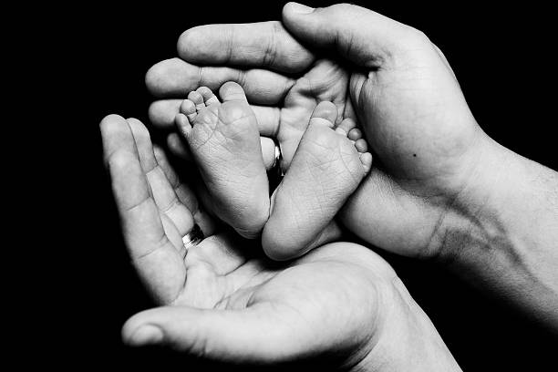 istock Baby Feet in Parent's hands 473149396