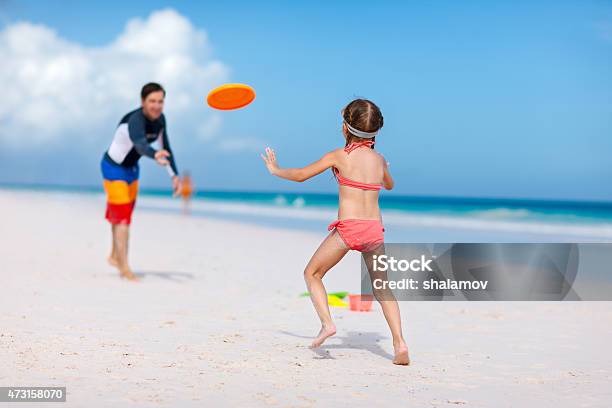 Father And Daughter Playing With Flying Disk Stock Photo - Download Image Now - 2015, Activity, Adult