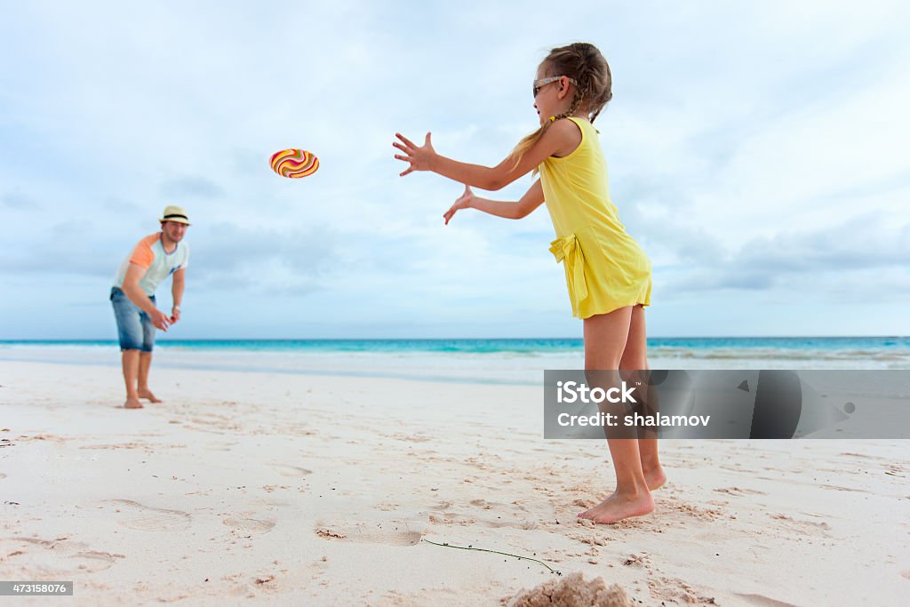 Father and daughter playing with flying disk Father and daughter playing with flying disk at beach 2015 Stock Photo