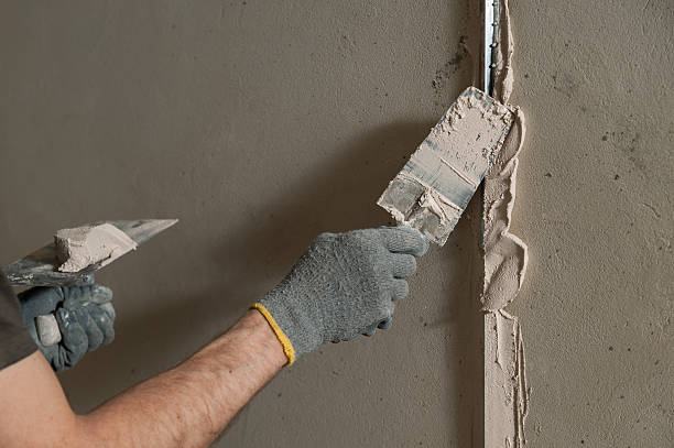 istock Woker fixes a guide to align the walls with stucco 473158108