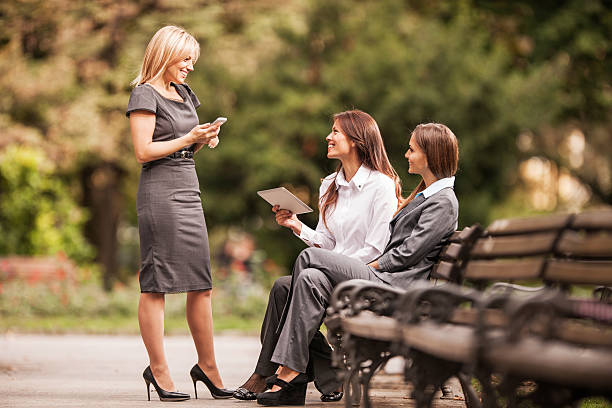 istock Three smiling businesswoman communicating on a break in the park. 473158586