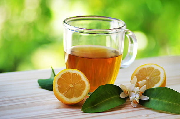 Glass cup of tea with lemon on table