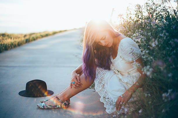 Beautiful girl with purple ombre hair A beautiful girl with purple ombre hair sitting among wild flowers.  purple hair stock pictures, royalty-free photos & images