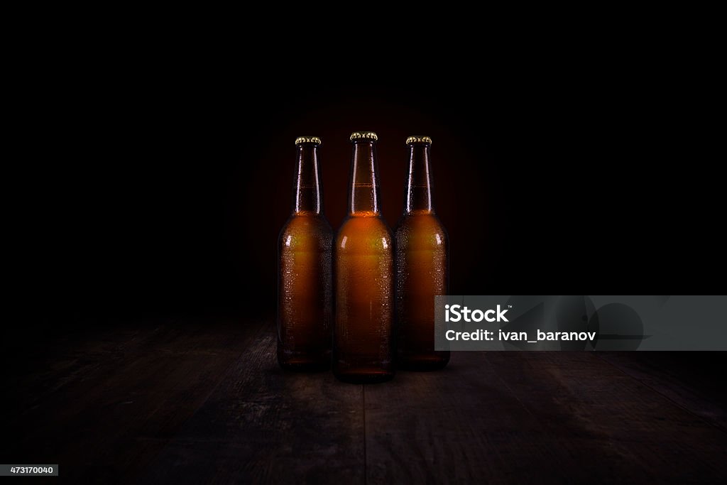 Three beer bottles on a rustic wooden table Beer - Alcohol Stock Photo