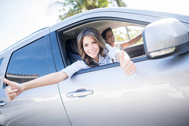 coppia di guida di un auto - car insurance women driving foto e immagini stock