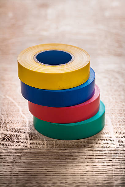 istock stack of four rolls insulating tape on wooden board construction 473173392