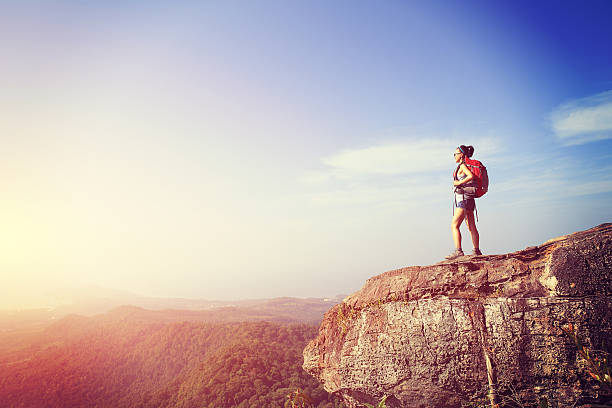 istock cheering young woman hiker  at mountain peak 473173436