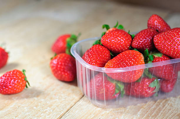 istock Strawberry in plastic box on wooden background 473174224