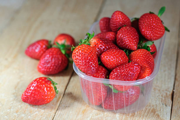 istock Strawberry in plastic box on wooden background 473174232