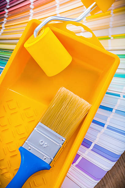 istock single paint brush in tray with roller on color palette 473174758